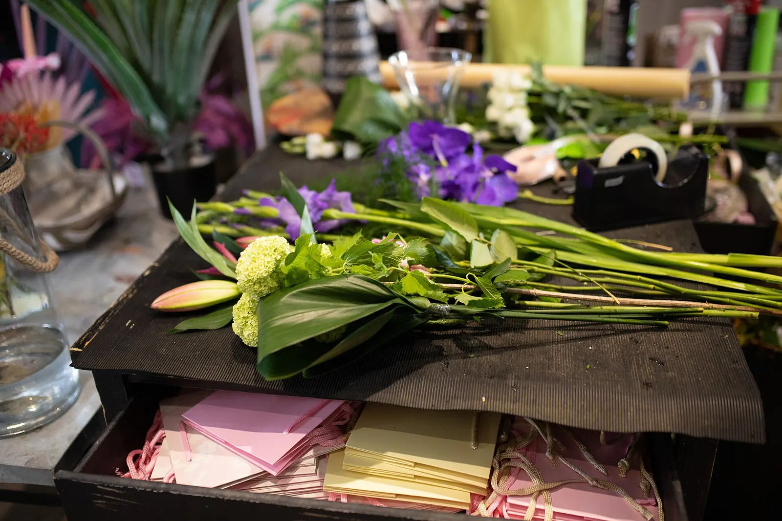 Werktisch einer Floristin mit Schnittblumen und Papier