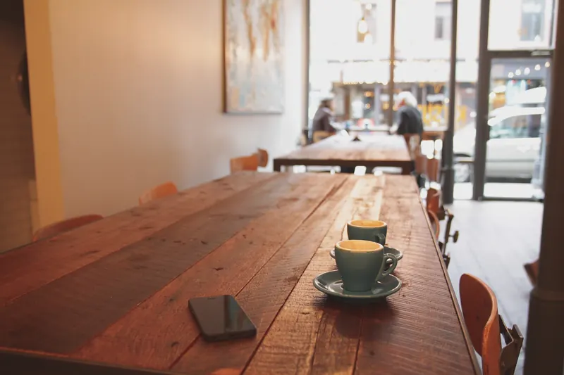 Langer Holztisch im Café mit Kaffeetassen